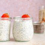 Two jars of kefir overnight oats topped with a mini strawberry.