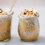 Peanut butter overnight oats topped with peanuts, cacao nibs, bananas, and sliced bananas.