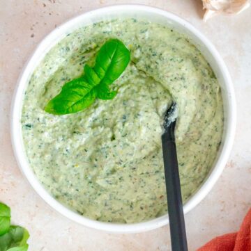 A bowl of ricotta pesto with basil leaves as garnish.