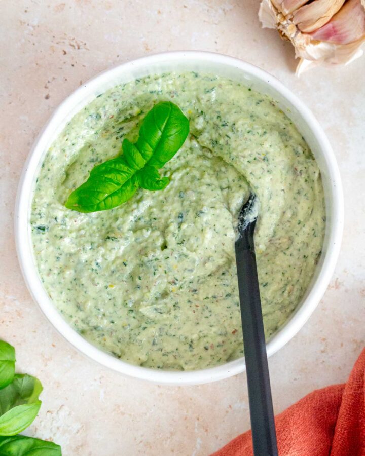 A bowl of ricotta pesto with basil leaves as garnish.