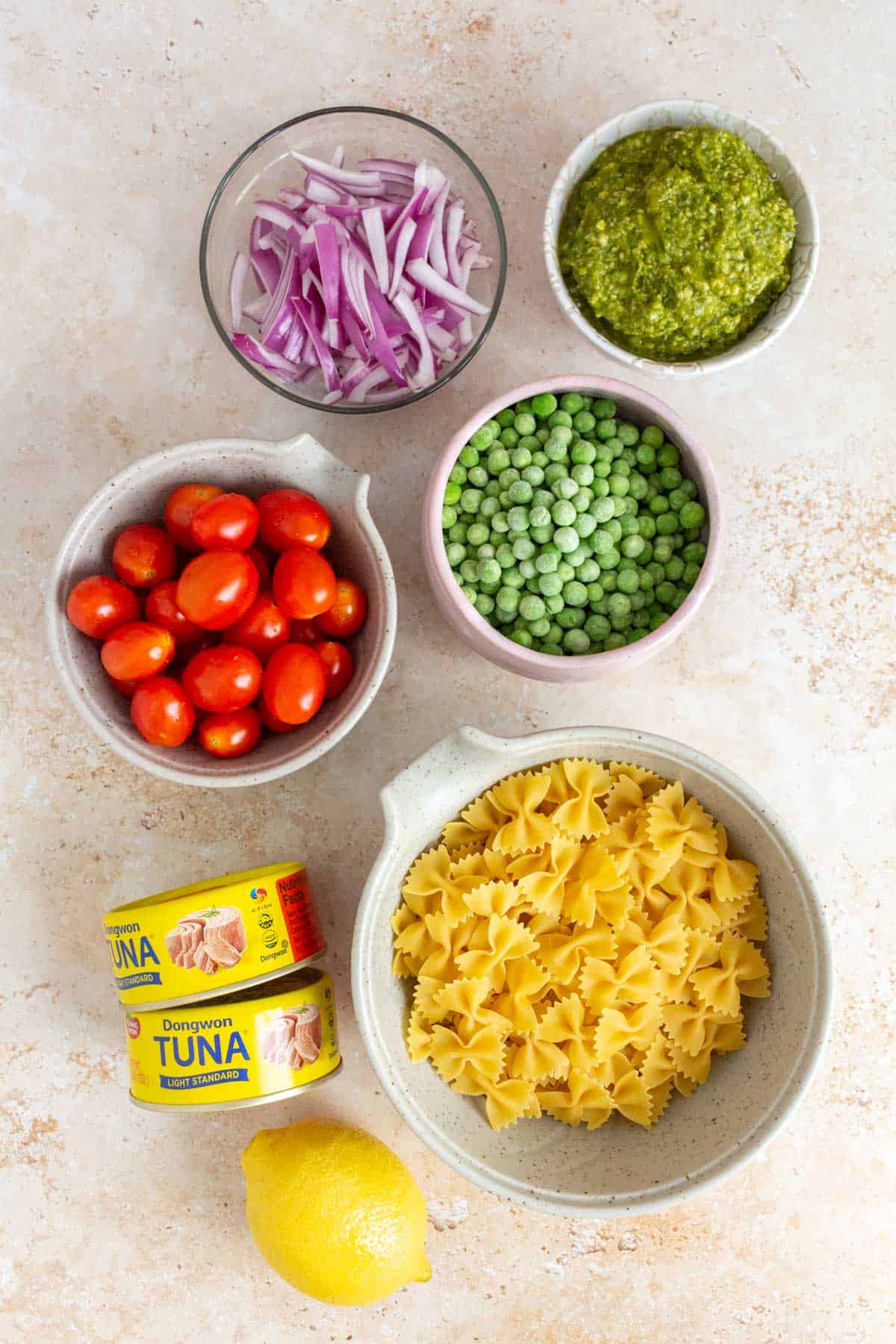 Ingredients needed to make tuna pesto pasta.