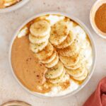 Overhead view of a cottage cheese peanut butter bowl surrounded by ingredients in pinch bowls.