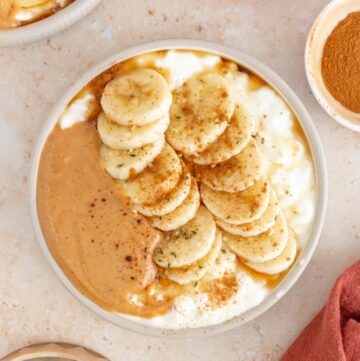 Overhead view of a cottage cheese peanut butter bowl surrounded by ingredients in pinch bowls.