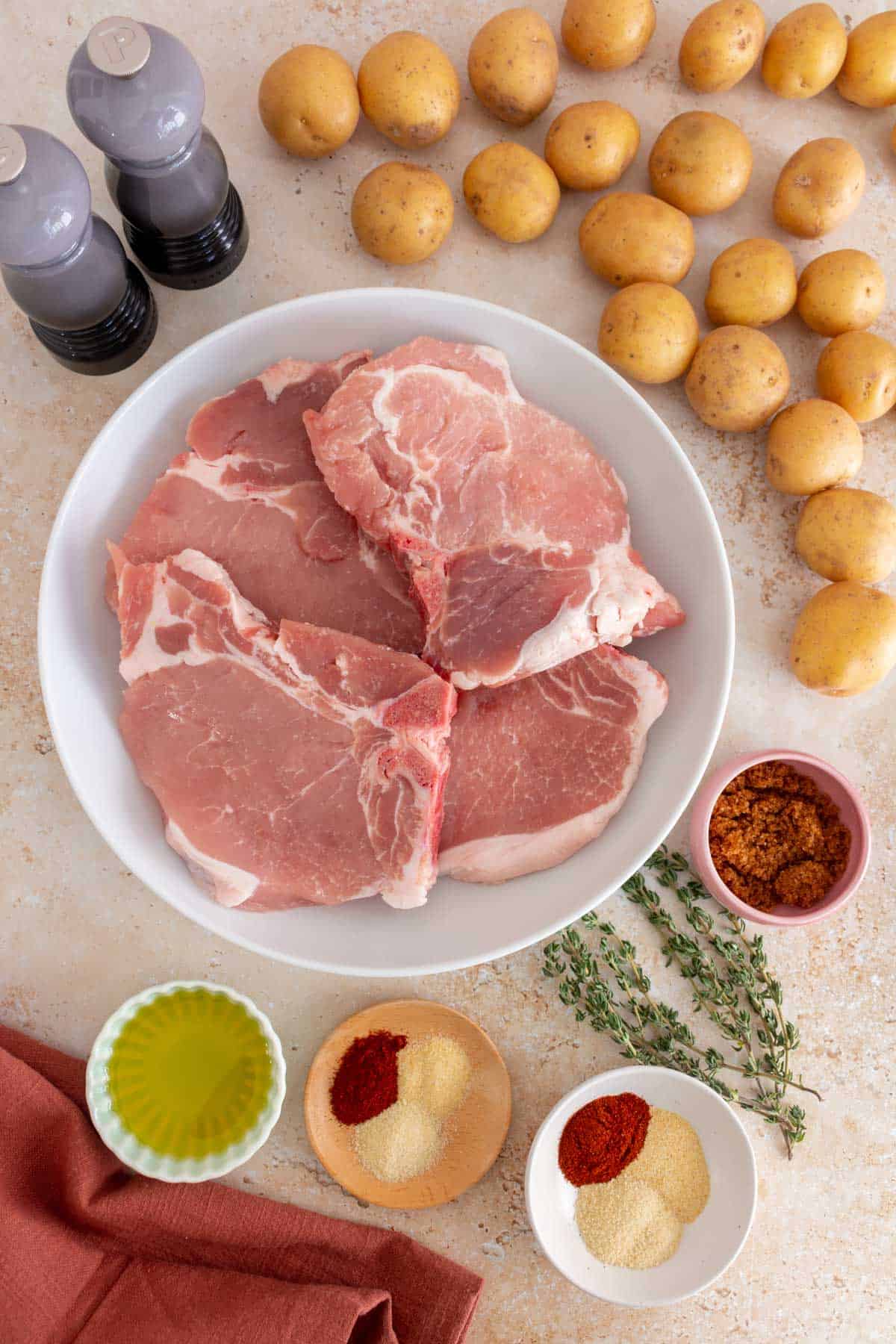 Ingredients needed to make oven baked bone-in pork chops with potatoes.