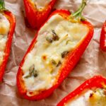 Close up of goat cheese stuffed peppers on wrinkled parchment.
