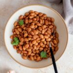 A plate of no soak instant pot pinto beans with a spoon insert.