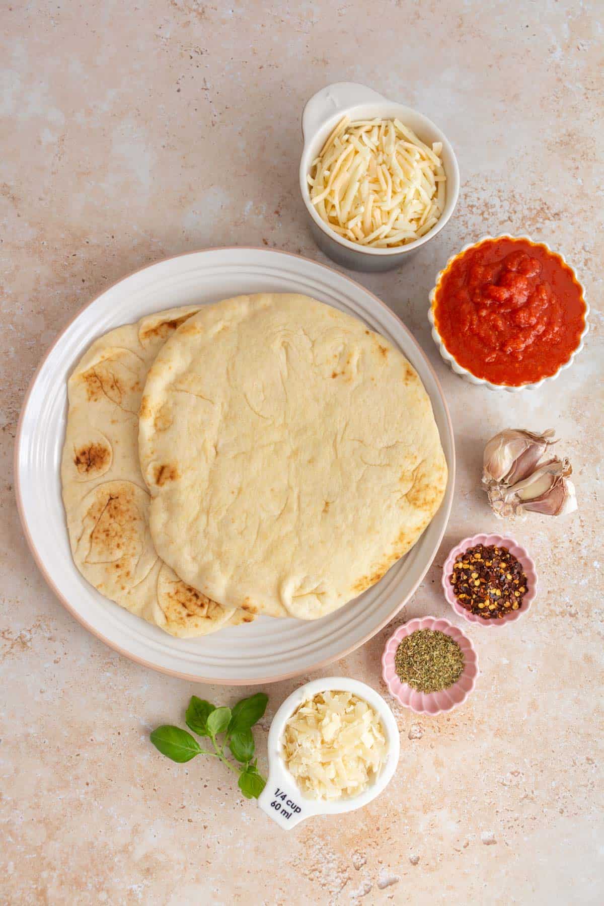 Ingredients needed to make cheese naan pizzas.