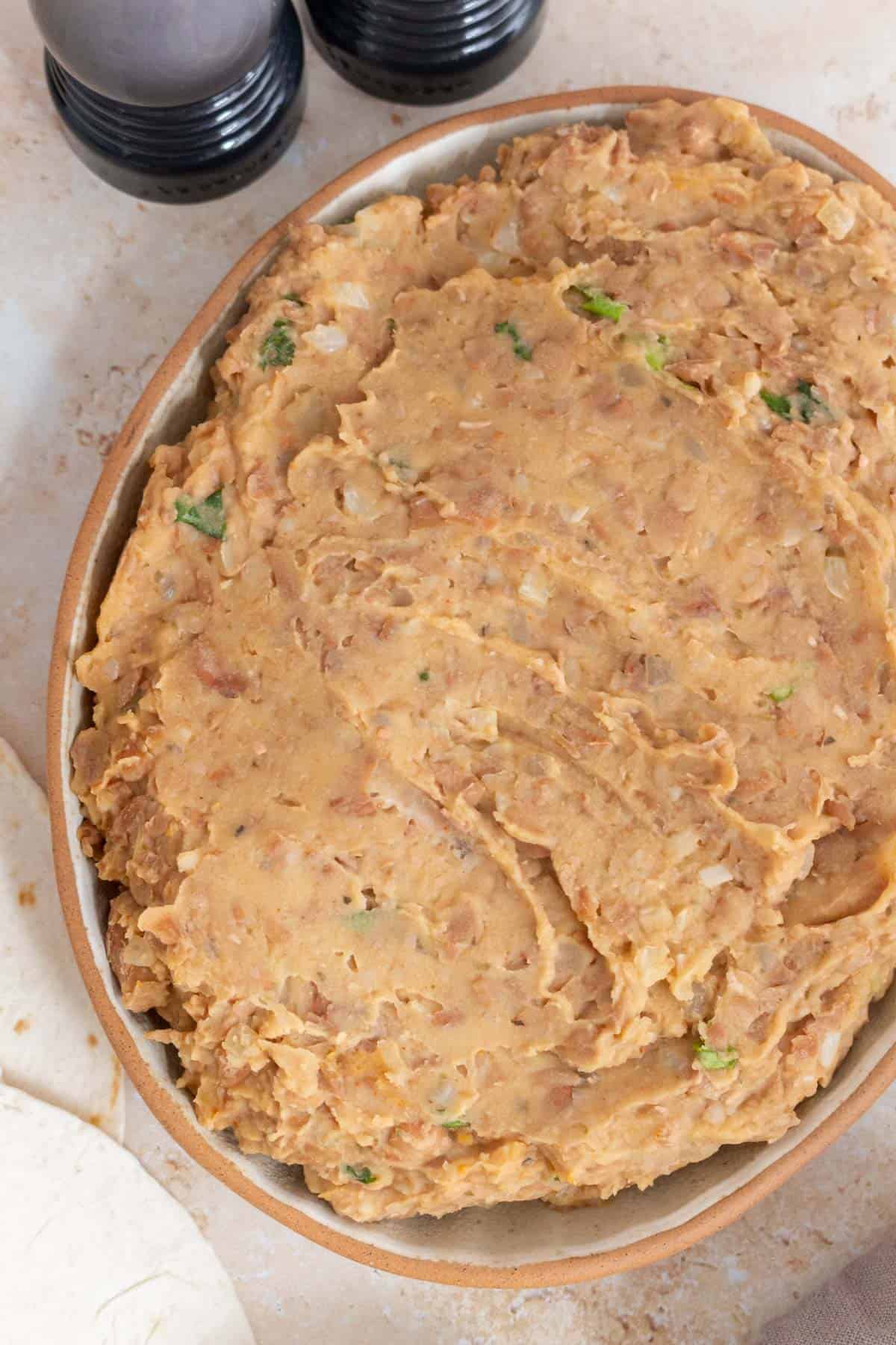 A close up view of a platter of refried beans.