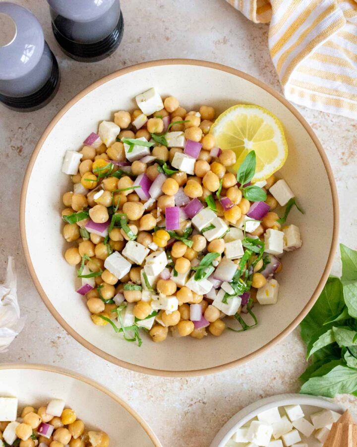 Overhead view of a bowl of chickpea feta salad with a lemon slice.