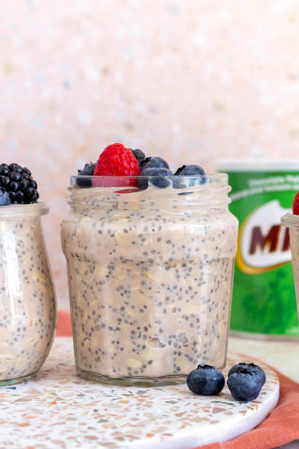 A jar of milo overnight oats topped with berries.