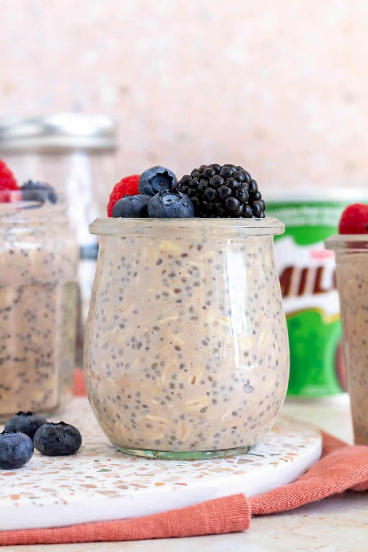 A jar of milo overnight oats topped with fresh berries.