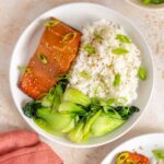 Overhead view of a plate of rice, miso salmon, and stir fried baby bok choy.