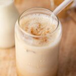 A glass of iced brown sugar oat milk shaken espresso with some cinnamon sprinkled on top.
