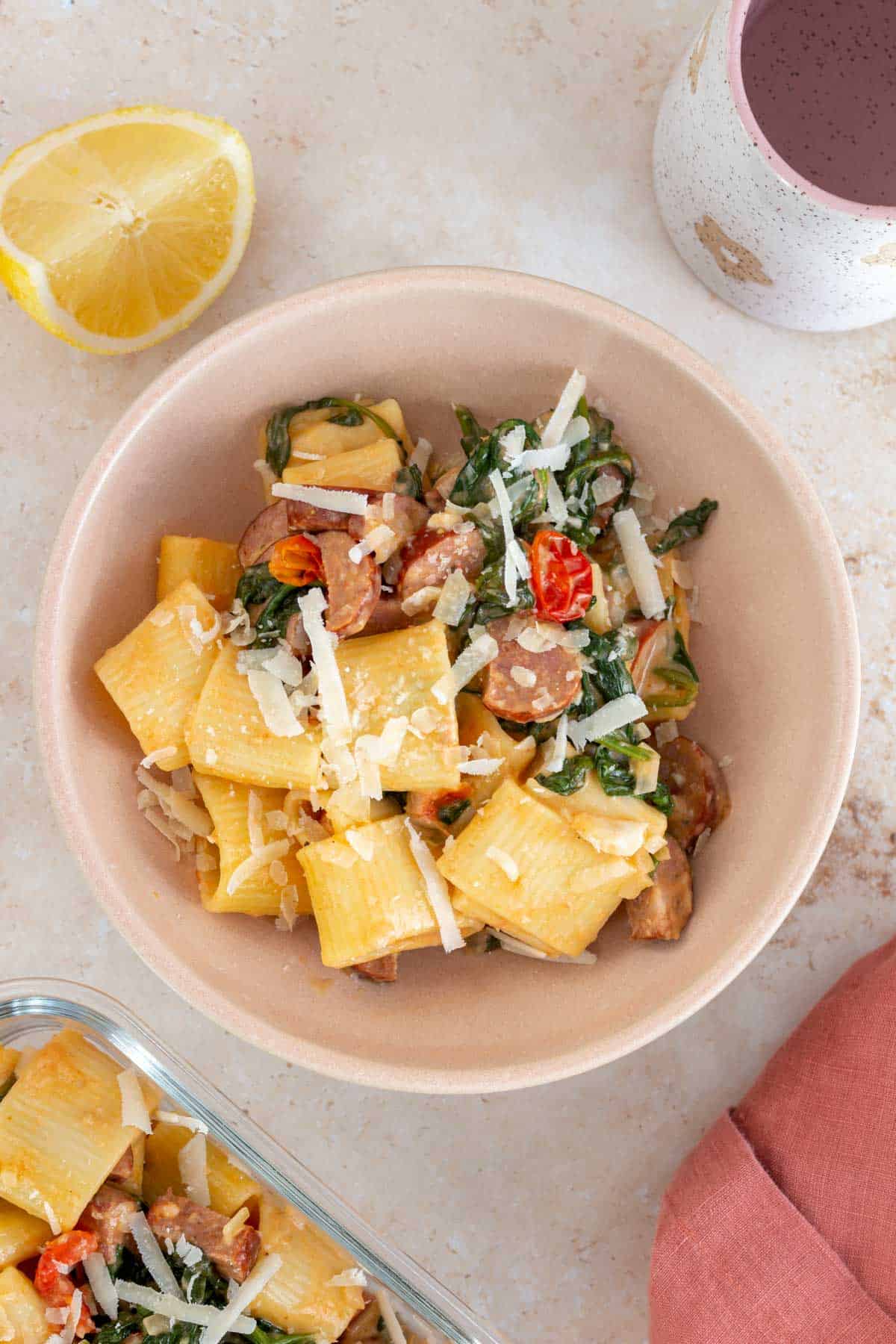 Overhead view of a bowl of chorizo and spinach pasta topped with parmesan.