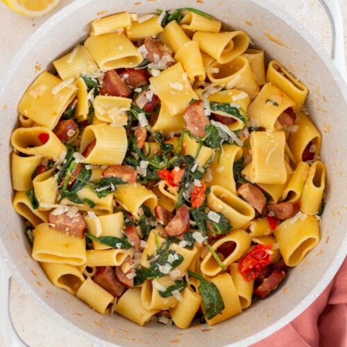 Overhead view of a pot of chorizo and spinach pasta with parmesan.