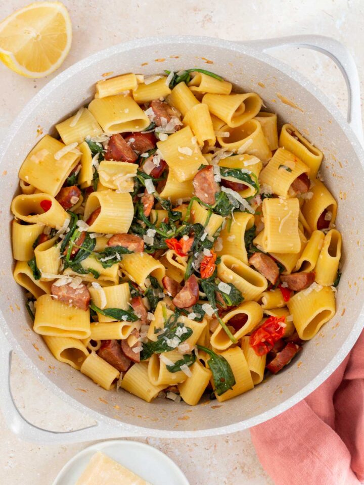Overhead view of a pot of chorizo and spinach pasta with parmesan.