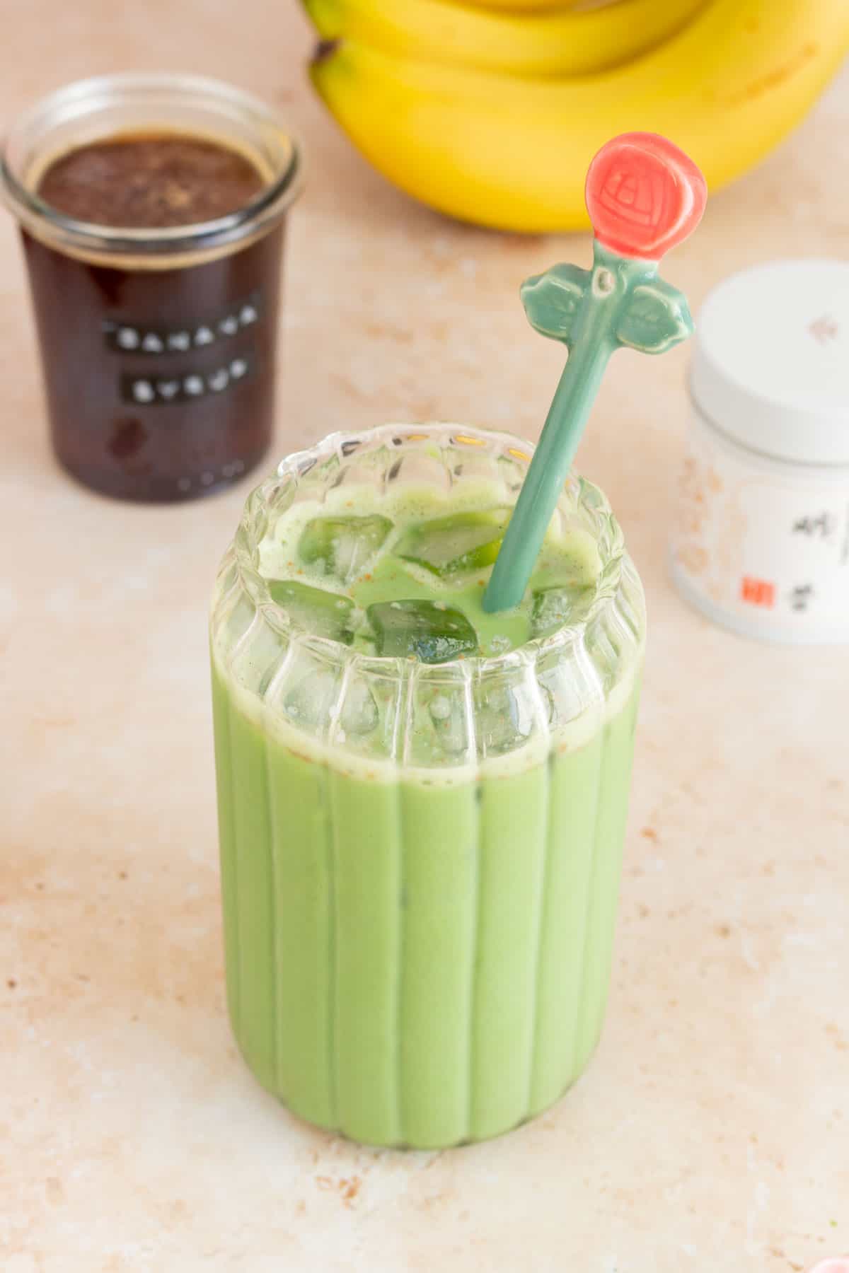 A slightly overhead view of a glass of banana bread matcha.
