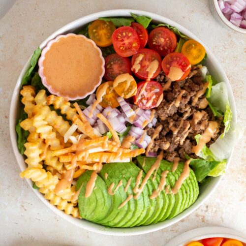 Overhead view of a burger bowl with special sauce drizzled over top.