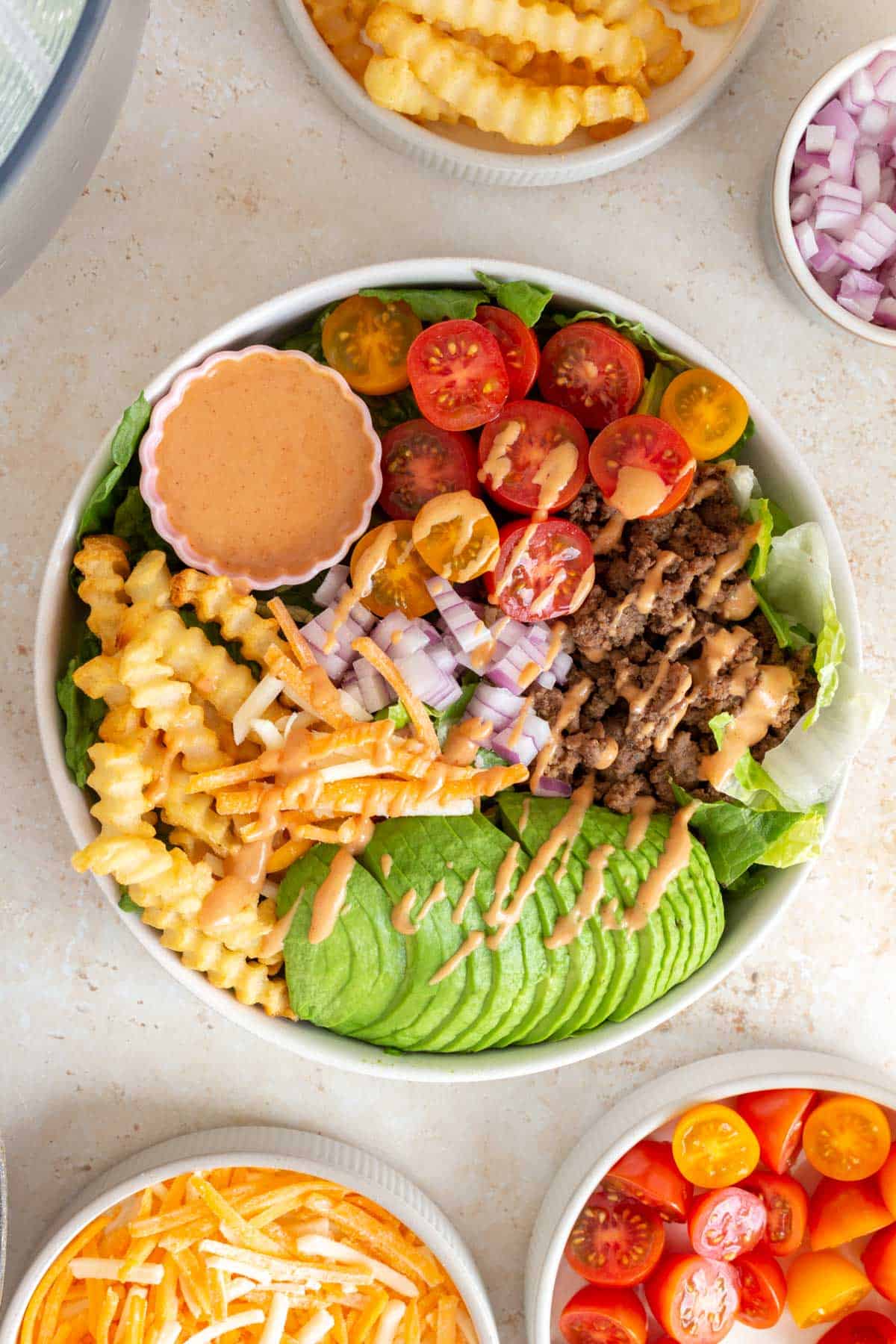 Overhead view of a burger bowl with special sauce drizzled over top.