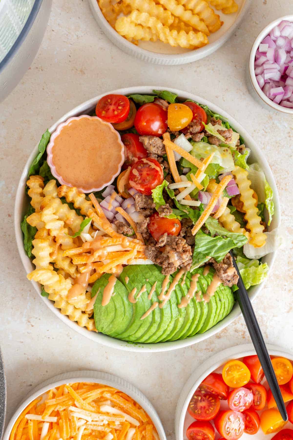 A burger bowl with special sauce in the process of being eaten.