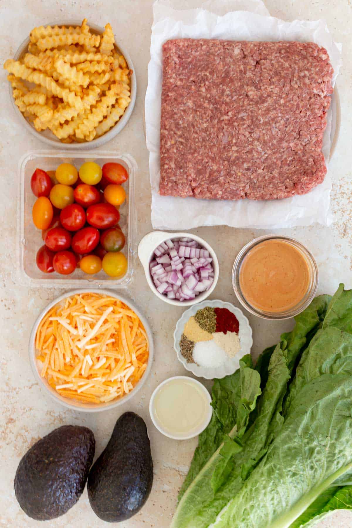 Ingredients needed to make a burger bowl with special sauce.