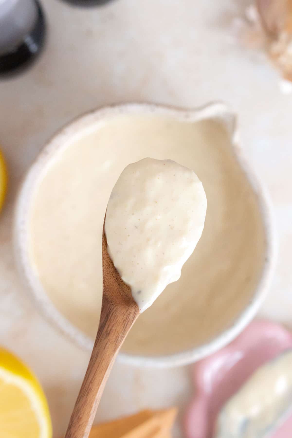 A spoonful of homemade caesar salad dressing lifted from the bowl.