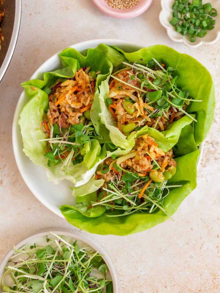 A plate with three firecracker ground chicken lettuce wraps.