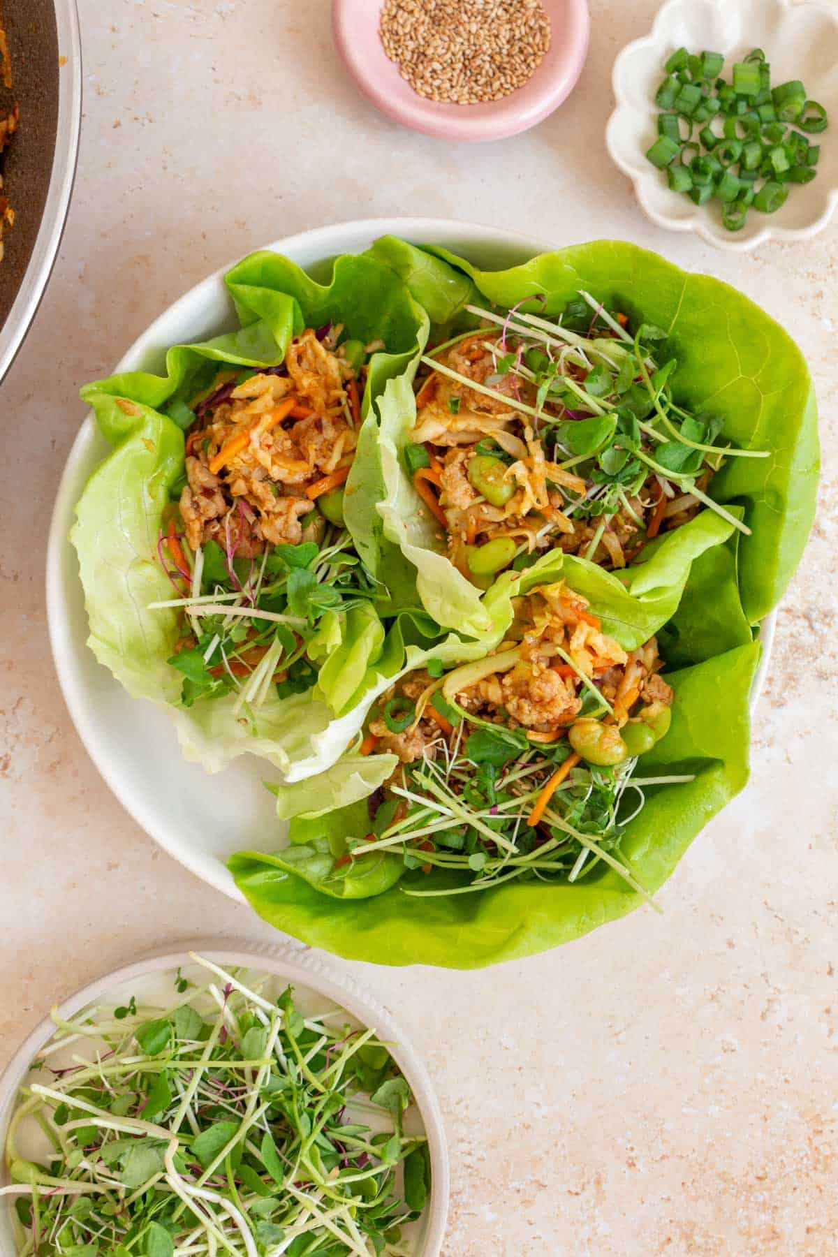 A plate with three firecracker ground chicken lettuce wraps.