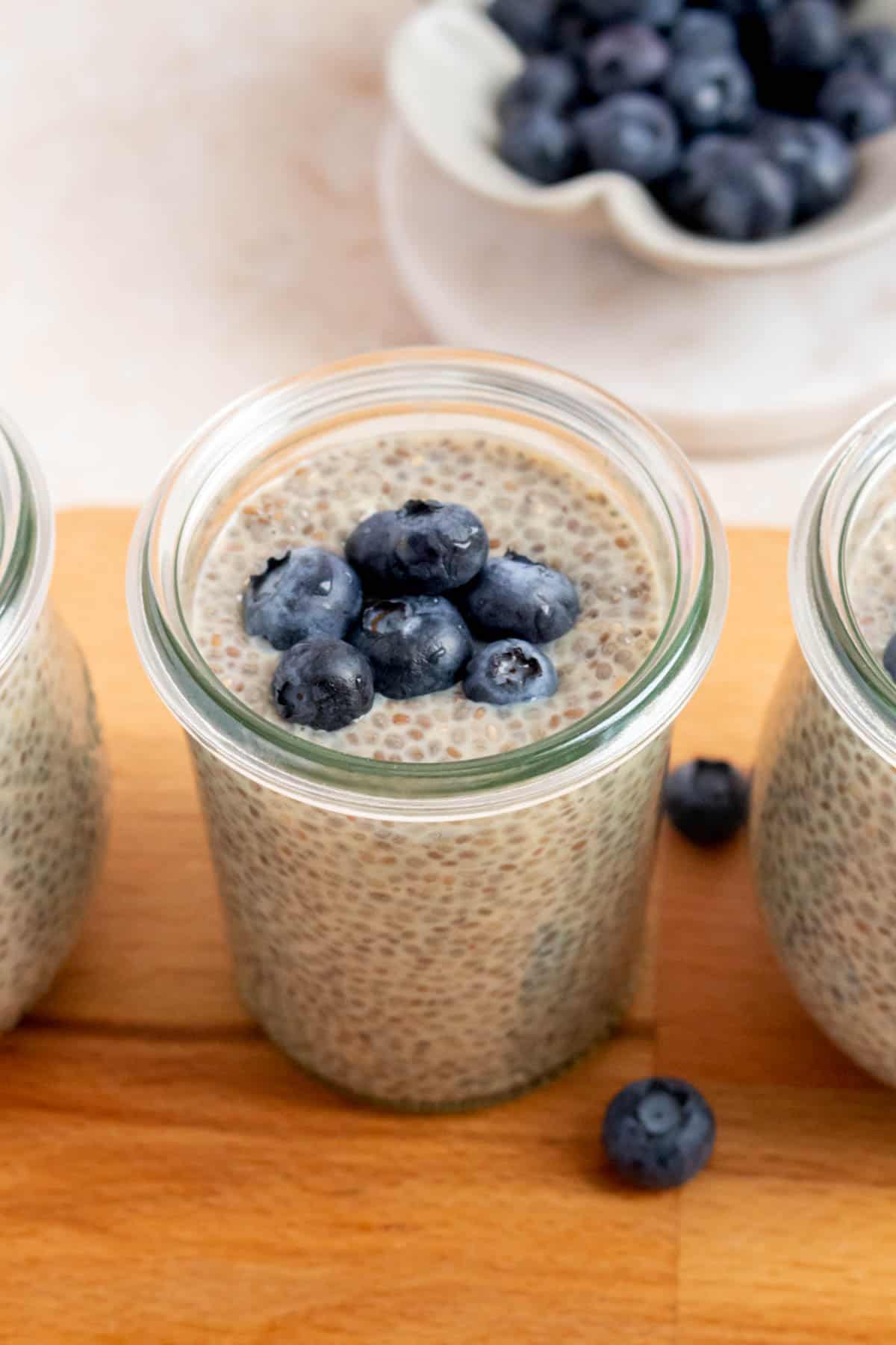 A jar of earl grey chia pudding topped with blueberries.