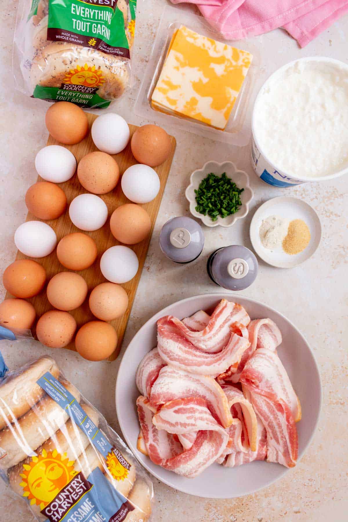 Ingredients needed to make a bacon, egg, and cheese bagel.