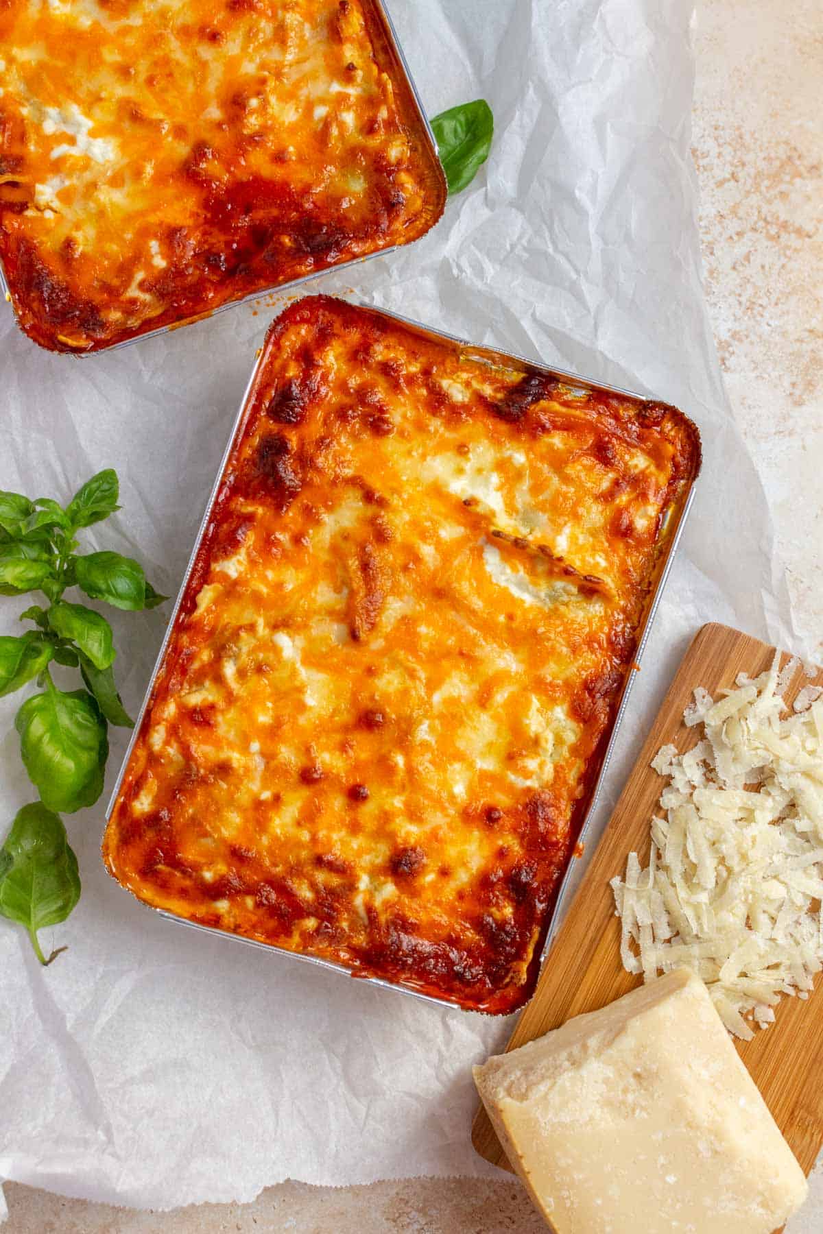 Small serving of ravioli lasagna baked in aluminum trays for the freezer.