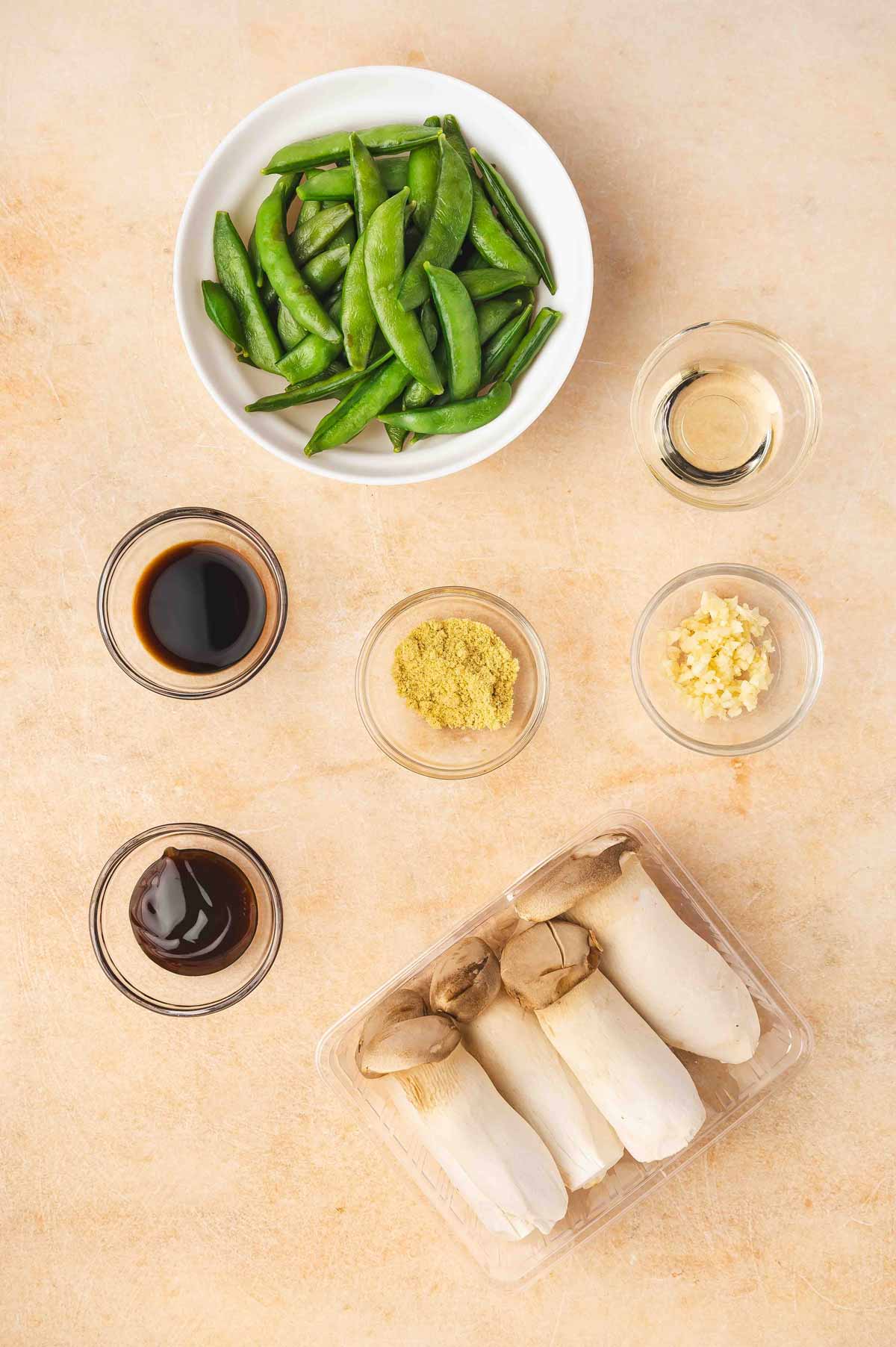 Ingredients needed to make baby king oyster mushroom and snap peas stir fry.