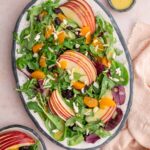 A platter of mandarin orange salad with extra dressing on the side.