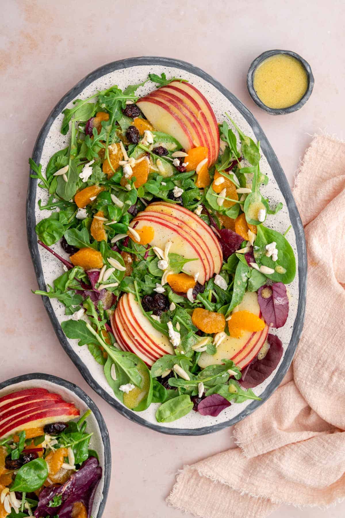 A platter of mandarin orange salad with extra dressing on the side.