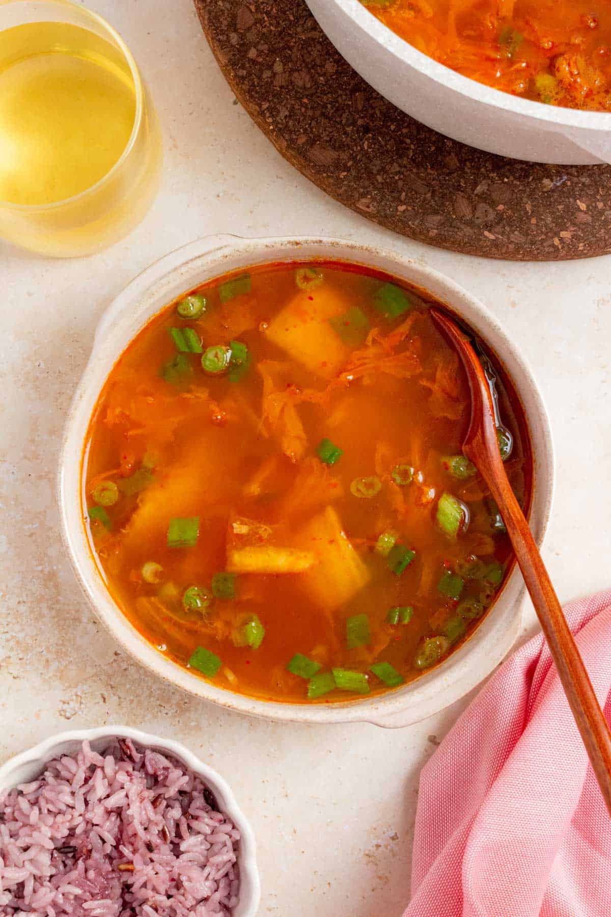A bowl of tuna kimchi stew with a spoon.