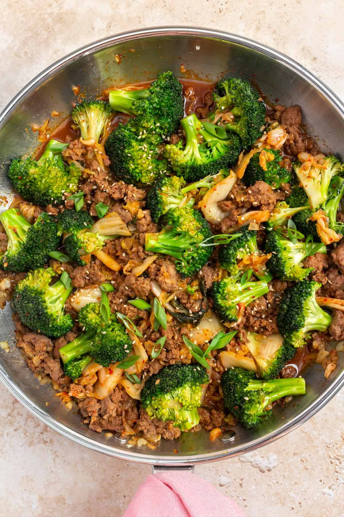 Close up of gochujang beef and broccoli and kimchi in a skillet.