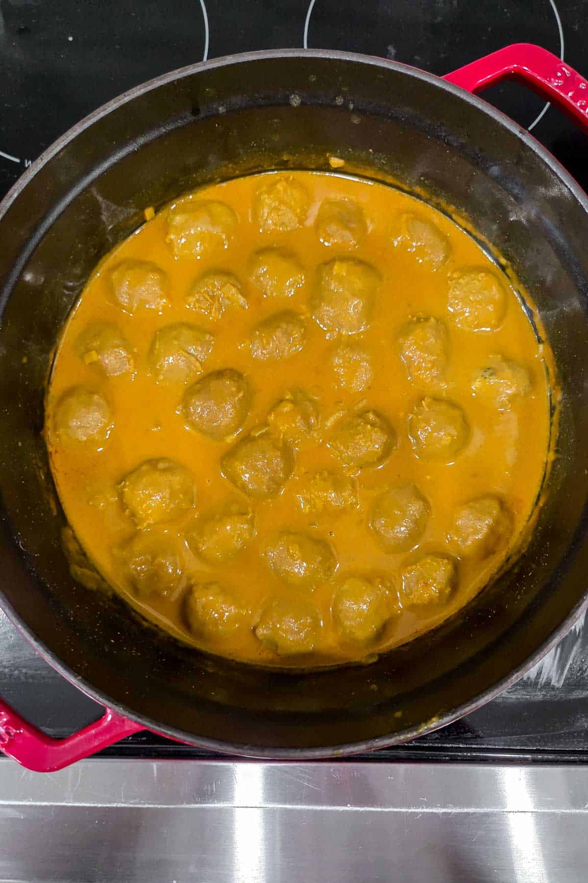Overhead view of a pot of hong kong curry balls.